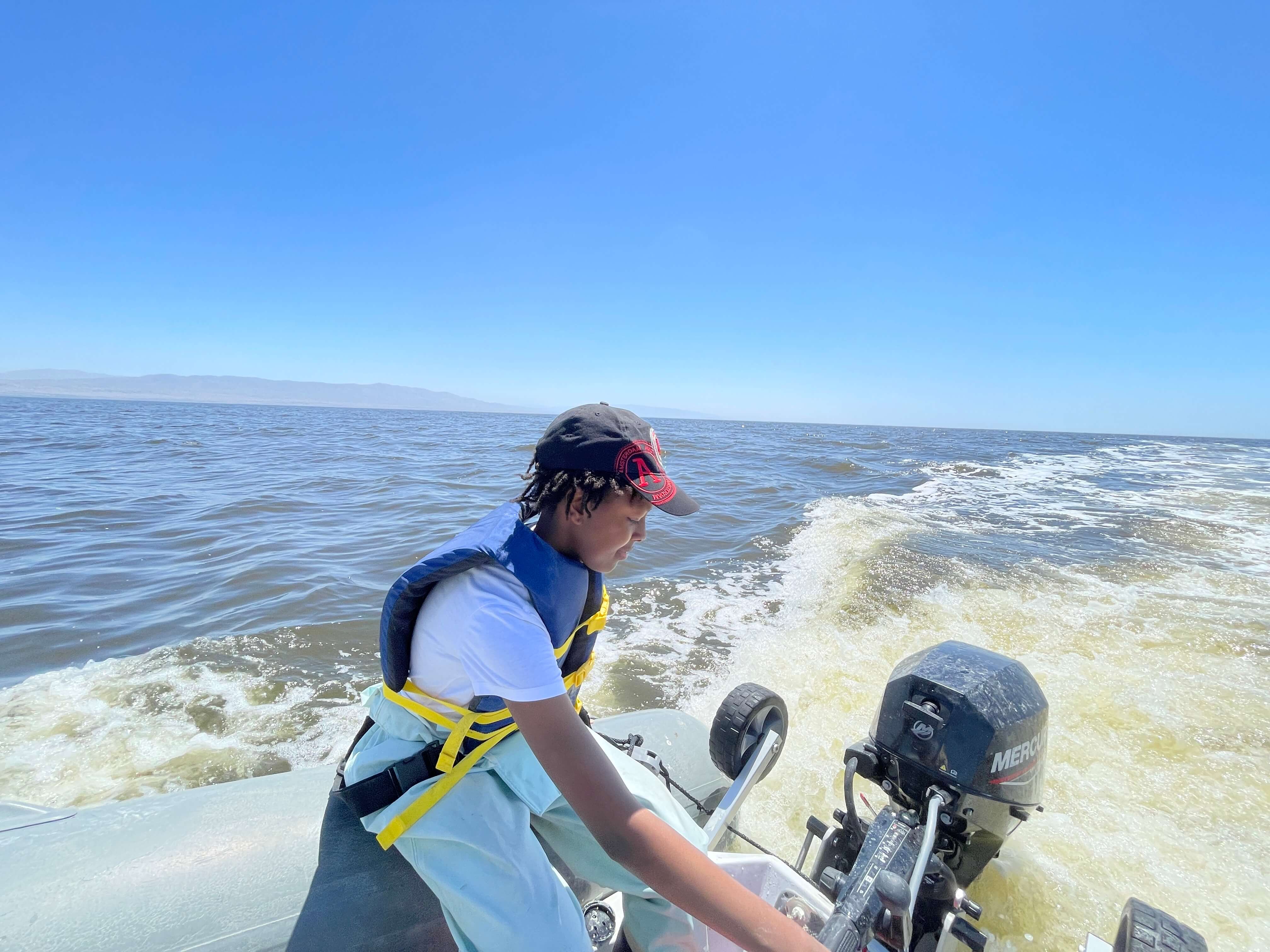 child on boat steering